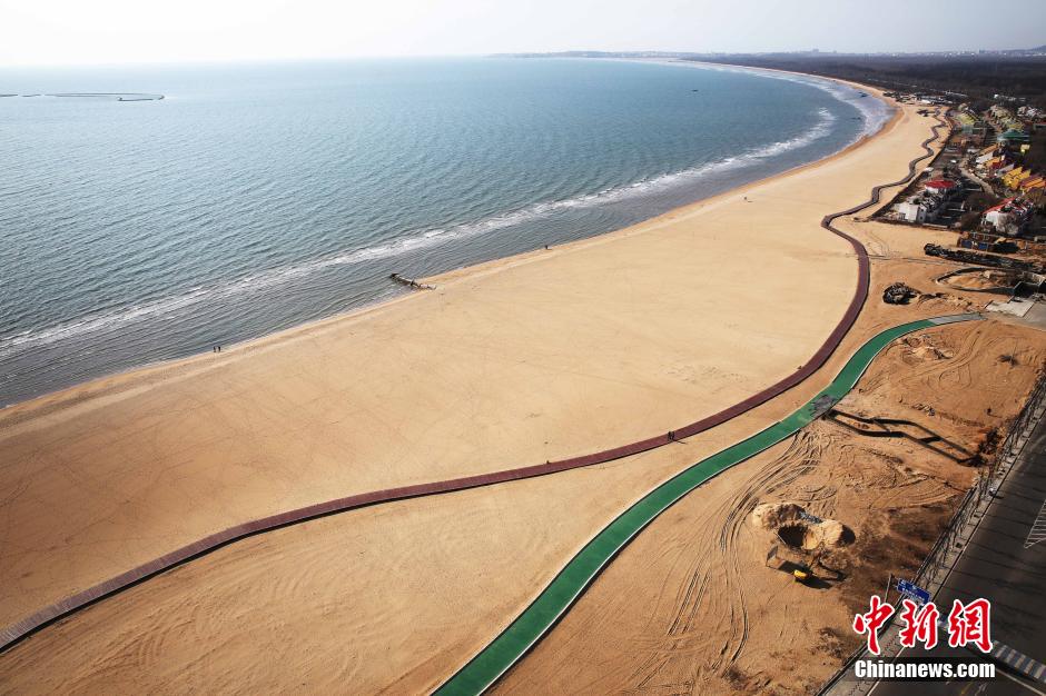 3月13日，秦皇島萬(wàn)米臨海沙灘木棧道。據(jù)了解，該木棧道全長(zhǎng)約4200米，與北戴河區(qū)原有的7500米木棧道對(duì)接后全線總長(zhǎng)度1.17萬(wàn)米，整個(gè)木棧道東起秦皇島體育基地游船碼頭，西至北戴河濕地公園，呈波浪形蜿蜒10.4公里海岸線。 中新社發(fā) 曹建雄 攝 CNSPHOTO